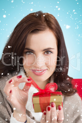 Composite image of pretty brunette opening gift