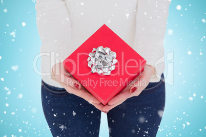 Composite image of woman with nail varnish holding red gift