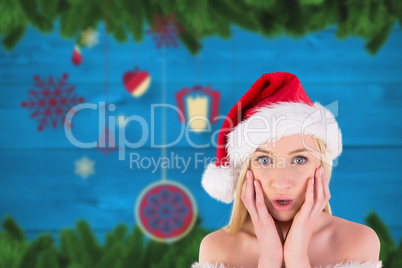 Composite image of festive blonde looking surprised with hands o