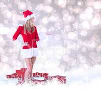 Composite image of pretty santa girl presenting with hand