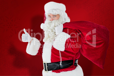 Composite image of positive santa with his sack and thumbs up
