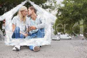 Composite image of cute young couple sitting on skateboard kissi