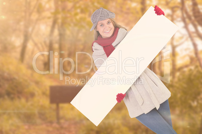 Composite image of happy blonde in winter clothes showing card