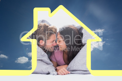 Composite image of beautiful couple wrapped in the duvet