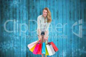 Composite image of smiling woman standing with many shopping bag