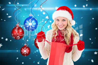 Composite image of happy festive blonde with shopping bag