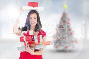 Composite image of smiling brunette holding many gifts