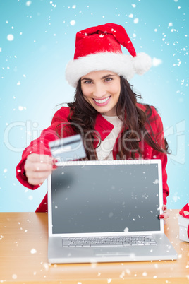 Composite image of festive brunette shopping online