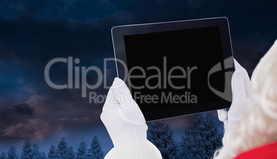 Composite image of santa claus using tablet pc Composite image of santa claus using tablet pc