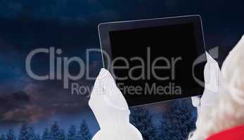 Composite image of santa claus using tablet pc