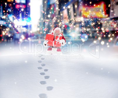 Composite image of santa carrying gifts in the snow