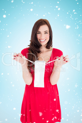 Composite image of stylish brunette in red dress holding shoppin