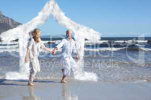 Composite image of happy couple skipping barefoot on the beach