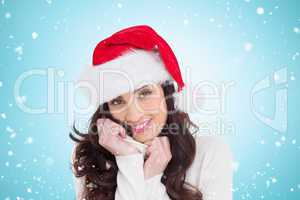Composite image of beautiful brunette in santa hat smiling at ca