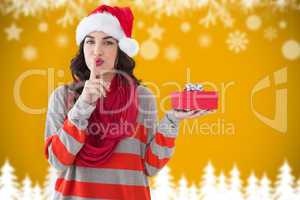 Composite image of festive brunette with gift