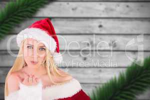 Composite image of festive blonde blowing a kiss