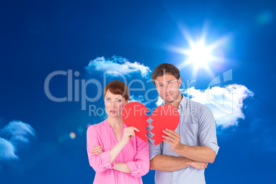 Composite image of couple holding a broken heart