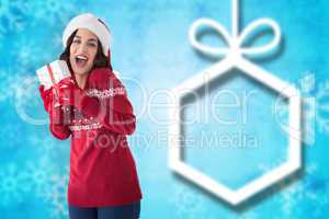 Composite image of excited brunette showing christmas present