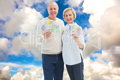 Composite image of happy mature couple smiling at camera showing