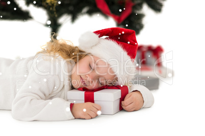 Composite image of festive little girl napping on a gift