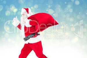 Composite image of positive santa with a sack and thumbs up
