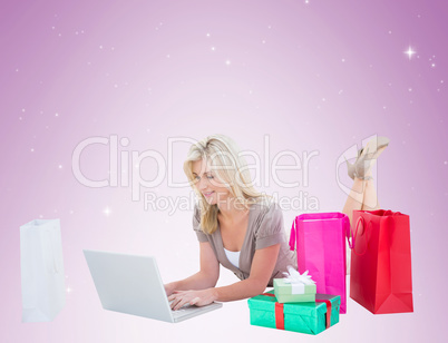 Happy blonde shopping online with laptop