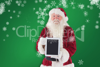 Composite image of santa presents a tablet pc