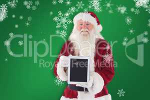 Composite image of santa presents a tablet pc