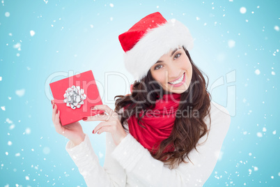 Composite image of joyful brunette presenting christmas gift
