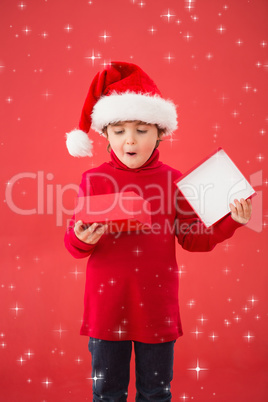 Composite image of festive little boy opening a gift Composite image of festive little boy opening a gift