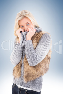 Blonde in winter clothes smiling at camera