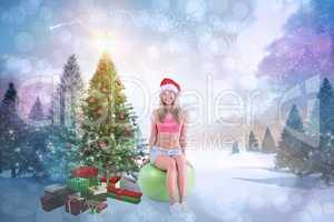 Composite image of festive fit blonde sitting on exercise ball