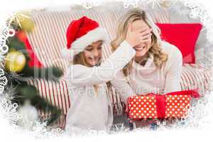 Composite image of festive mother and daughter with gift