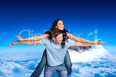 Composite image of young man giving girlfriend a piggyback ride