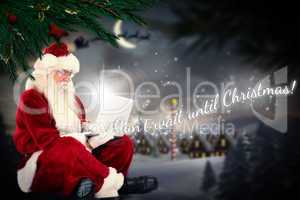 Composite image of santa sits and uses a laptop