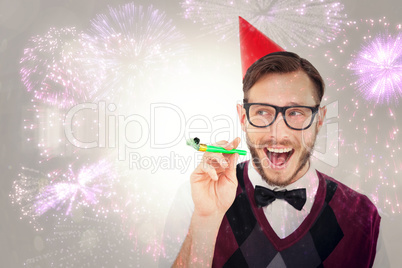 Composite image of geeky hipster in party hat with horn