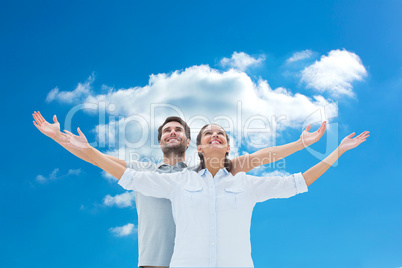 Composite image of cute couple standing with arms out