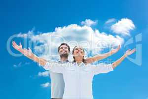 Composite image of cute couple standing with arms out