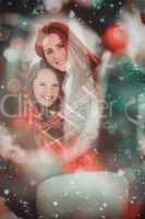 Composite image of festive mother and daughter wrapped in blanke