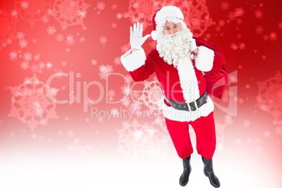 Composite image of santa holding a sack and waving