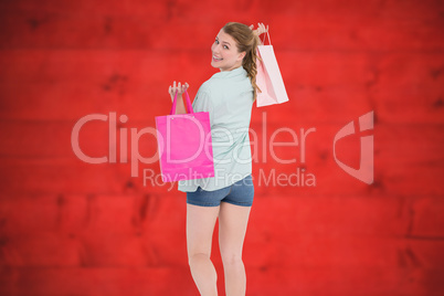 Composite image of woman carrying shopping bags over her shoulde