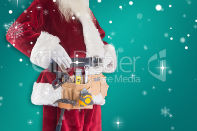 Composite image of father christmas is wearing a tool belt