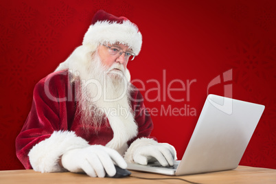 Composite image of santa surfs on the internet