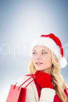 Composite image of happy festive blonde with shopping bag