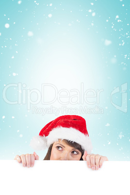 Festive brunette holding a poster while looking up