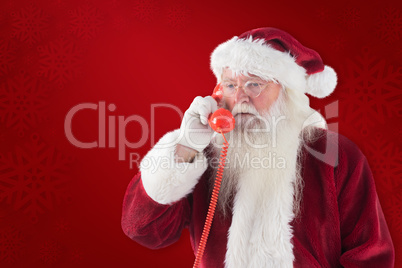 Composite image of santa on his red phone