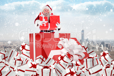 Composite image of santa standing in large gift