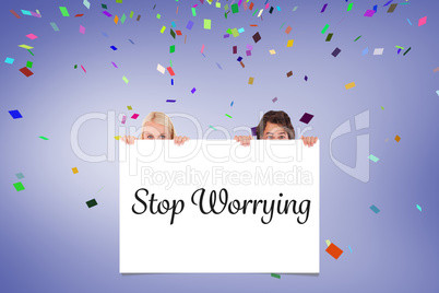 Composite image of happy couple hiding behind a whiteboard