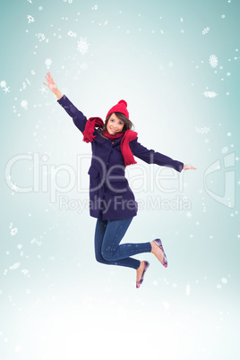 Composite image of woman in warm clothing jumping