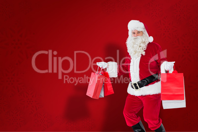 Composite image of smiling santa claus holding shopping bags